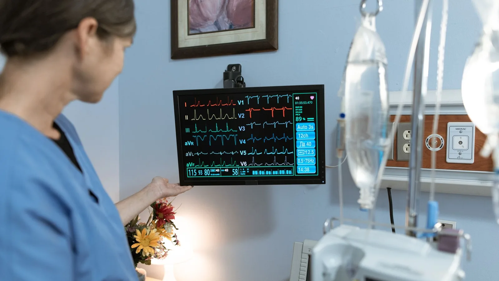 Profissional de enfermagem em UTI cercado por monitores e equipamentos hospitalares