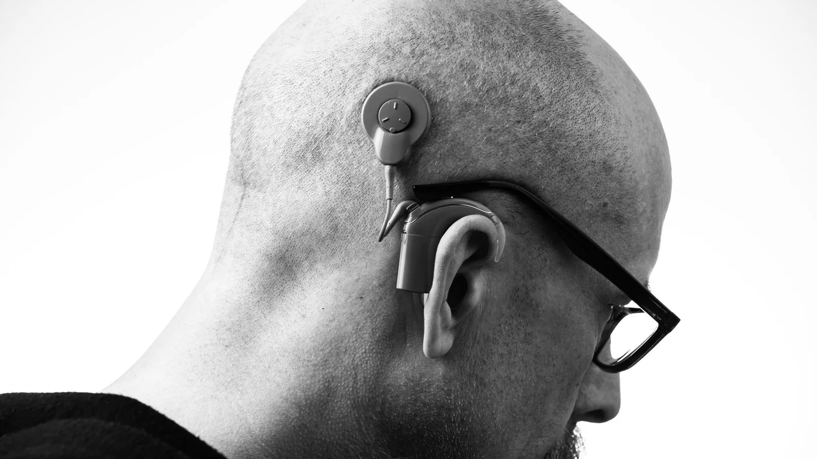 Idoso utilizando moderno aparelho auditivo com conectividade Bluetooth e inteligência artificial