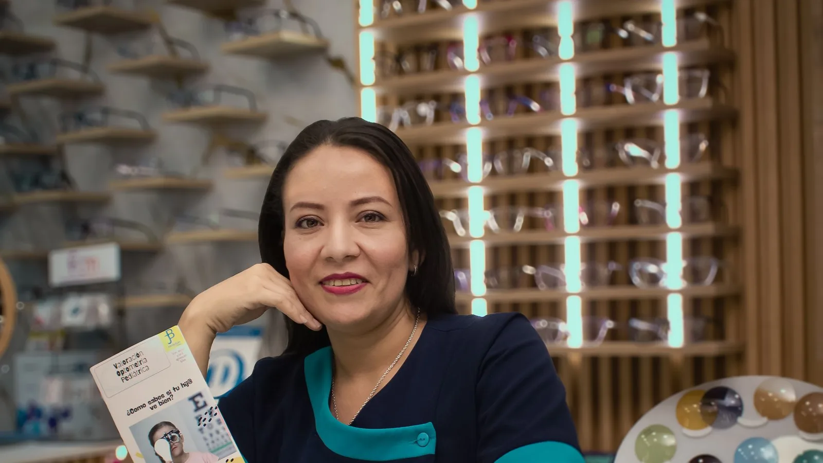Óptico exibindo coleção de óculos de grau para cliente na loja