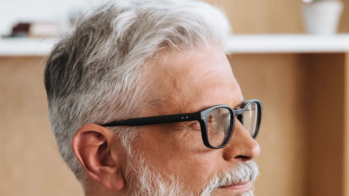Pessoa mais velha usando óculos de grau clássico