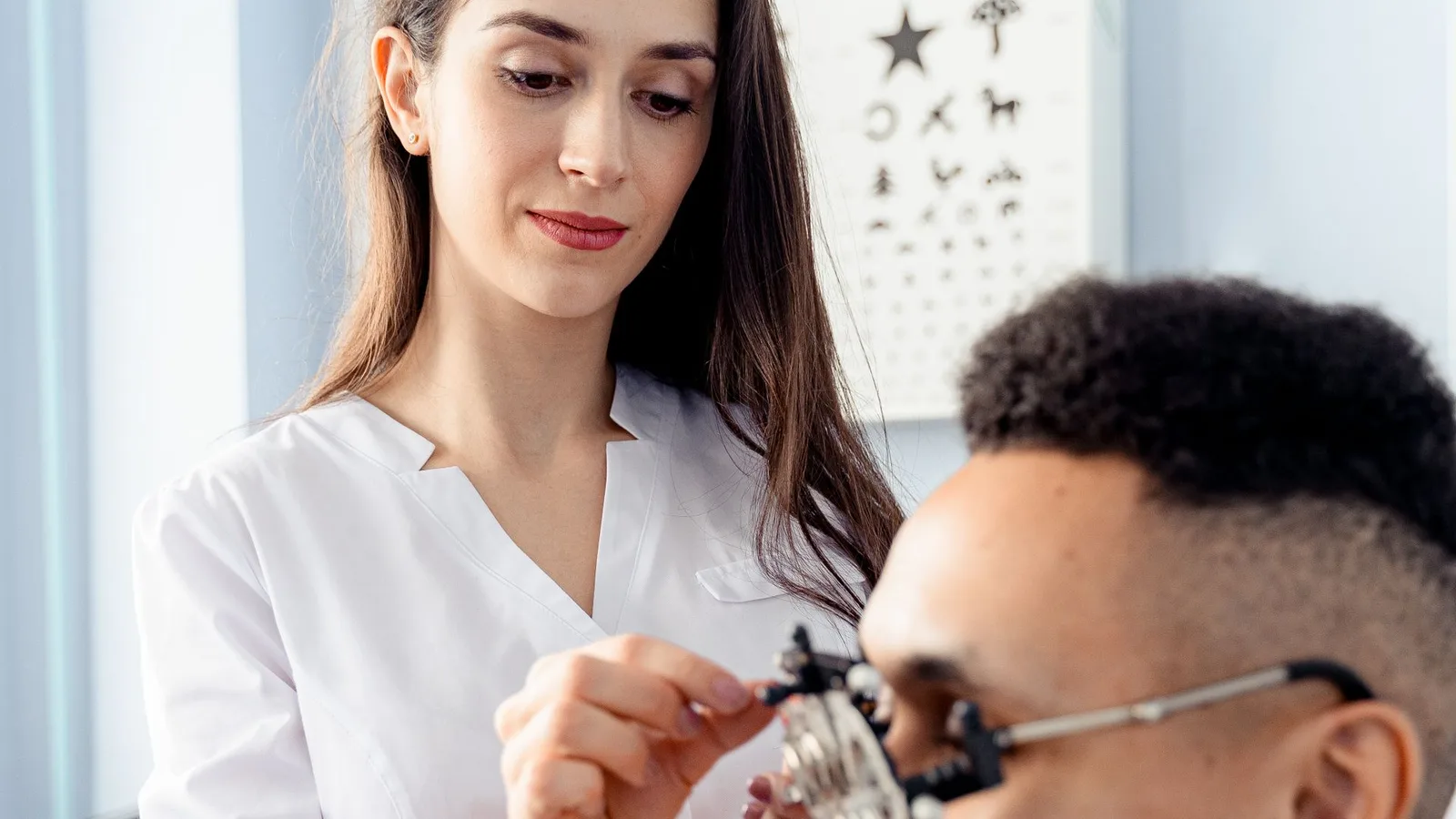 Optometrista ajustando armação de lentes multifocais durante exame de vista